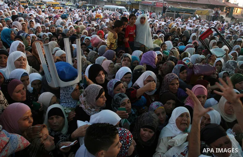 Palestinian women wait to cross the Qalandia checkpoint on their way to pray at the Al Aqsa Mosque on the third Friday of the Muslim holy month of Ramadan, at the Qalandia checkpoint between the West Bank city of Ramalla...