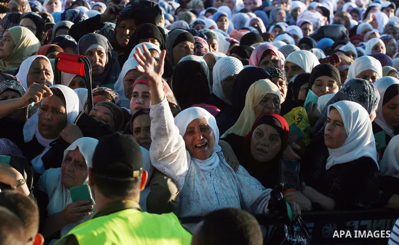 Palestinian women wait to cross the Qalandia checkpoint on their way to pray at the Al Aqsa Mosque on the third Friday of the Muslim holy month of Ramadan, at the Qalandia checkpoint between the West Bank city of Ramalla...