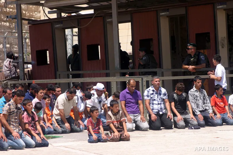 Israeli border guards keep watch as Palestinians attend the third friday prayer of Islam's holy fasting month of Ramadan outside the Ibrahimi mosque, or the Tomb of the Patriarchs, in the divided West Bank city of Hebron...