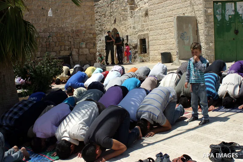 Israeli border guards keep watch as Palestinians attend the third friday prayer of Islam's holy fasting month of Ramadan outside the Ibrahimi mosque, or the Tomb of the Patriarchs, in the divided West Bank city of Hebron...