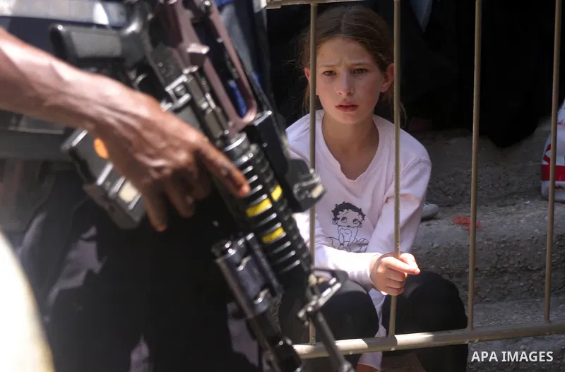 Israeli border guards keep watch as Palestinians attend the third friday prayer of Islam's holy fasting month of Ramadan outside the Ibrahimi mosque, or the Tomb of the Patriarchs, in the divided West Bank city of Hebron...