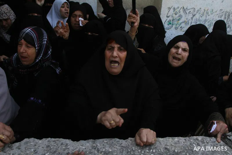 Palestinian relatives of Khaled Sha'at, a member of an armed Palestinian faction, and his two-year-old son Malek mourn during their funeral in Rafah in the southern Gaza Strip August 19, 2011. The Israeli air strike kill...