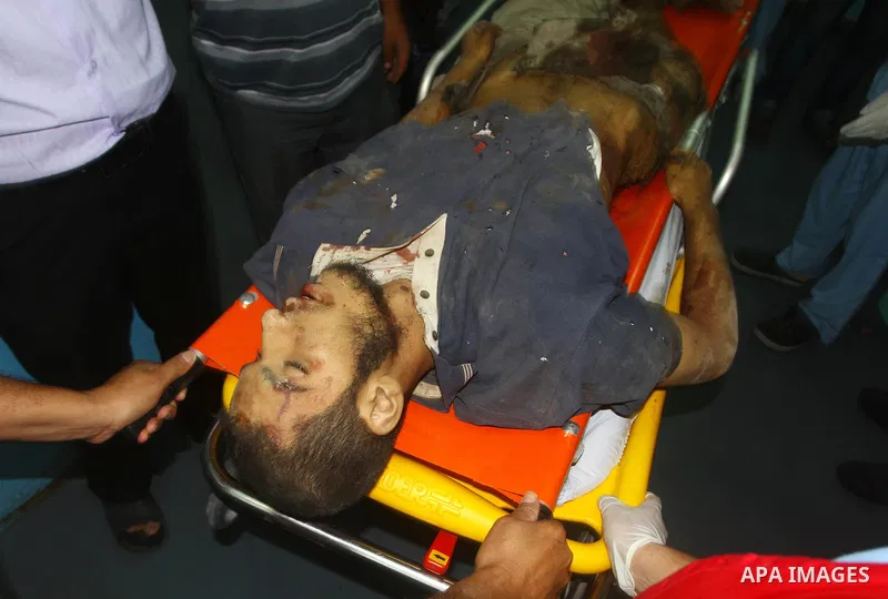 Palestinian men carry the body of Mohammed Enaya at the mortuary of Al-Shifa hospital after he was killed when the Israeli air force targeted an area in the eastern part of Gaza City on August 19, 2011. Photo by Ashraf A...