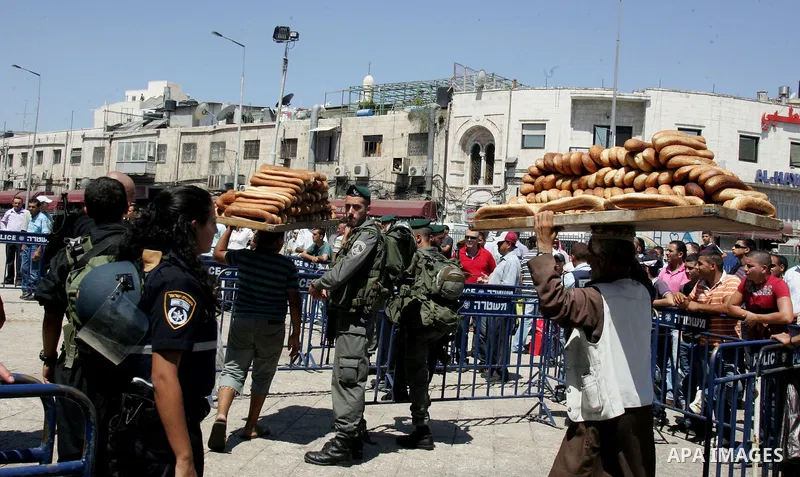 Israeli border policemen keep watch as Palestinian Muslim worshipers perform the third Friday prayer of Islam's holy month of Ramadan outside Damascus Gate in Jerusalem's Old City on August 19, 2011. Photo by Mahfouz Abu...