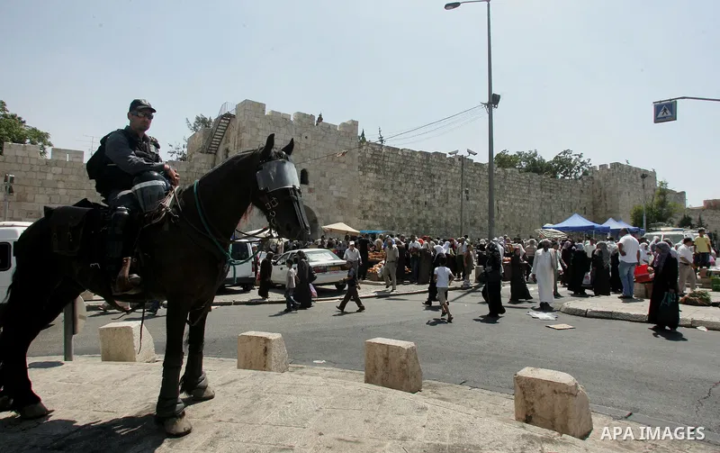 Israeli border policemen keep watch as Palestinian Muslim worshipers perform the third Friday prayer of Islam's holy month of Ramadan outside Damascus Gate in Jerusalem's Old City on August 19, 2011. Photo by Mahfouz Abu...