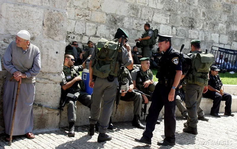 Israeli border policemen keep watch as Palestinian Muslim worshipers perform the third Friday prayer of Islam's holy month of Ramadan outside Damascus Gate in Jerusalem's Old City on August 19, 2011. Photo by Mahfouz Abu...