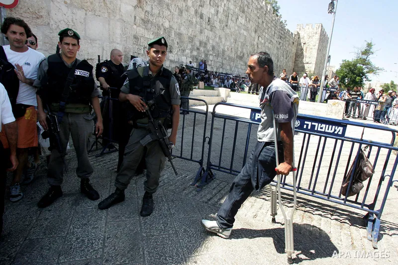 Israeli border policemen keep watch as Palestinian Muslim worshipers perform the third Friday prayer of Islam's holy month of Ramadan outside Damascus Gate in Jerusalem's Old City on August 19, 2011. Photo by Mahfouz Abu...