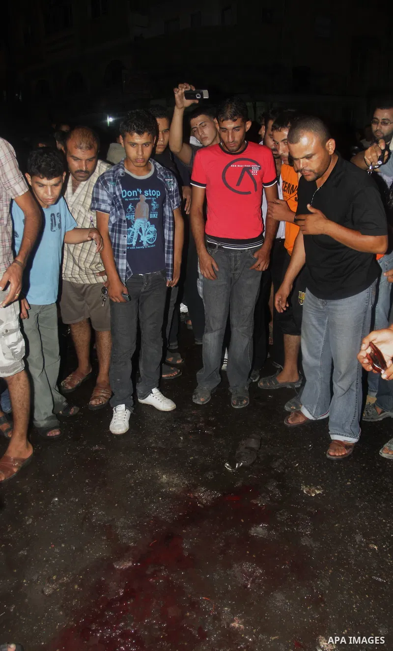 Palestinians inspect the Blood following an Israeli airstrike killing three Palestinian who were riding it, at the main road in Gaza City, Friday, Aug. 19, 2011. Palestinian official said that Dr. Monzer Qrakea, 35, and...
