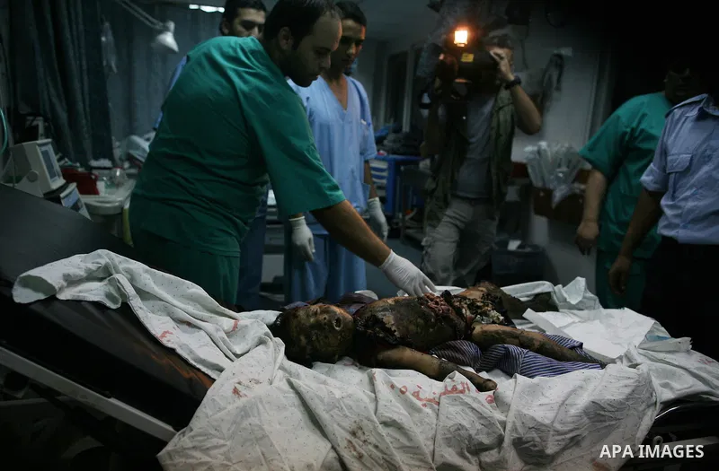 A Palestinian man carries the body of Islam Greagea, a five-year-old boy killed in an Israeli air strike, at a hospital in Gaza City on August 19, 2011. Three Palestinians were killed -- one of them a five-year-old boy -...