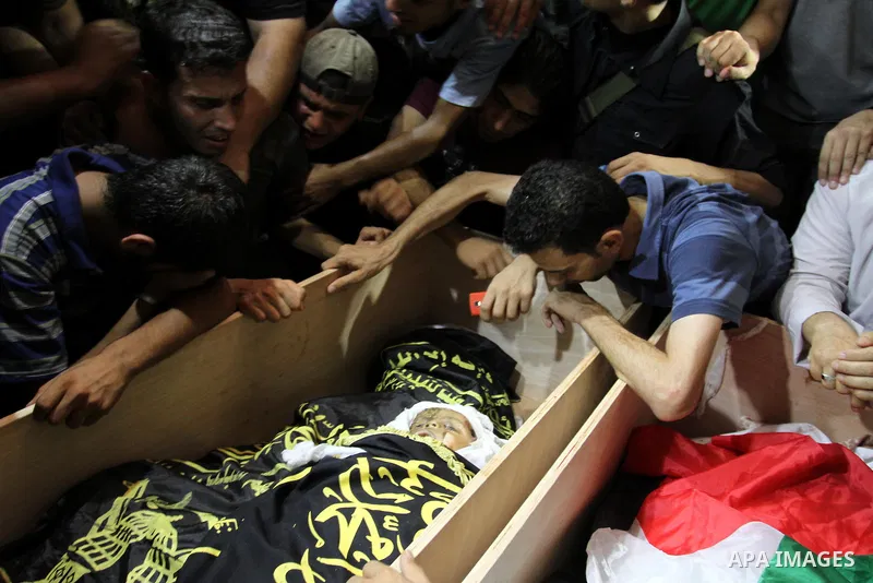 Palestinians mourn over the bodies of Moataz Qreqa, a commander of Islamic Jihad's Al-Quds Brigade, his five-year-old son Islam and his brother Munzer during their funeral in Gaza City on August 20, 2011 after all three...