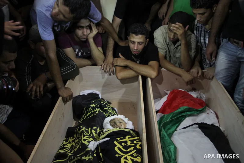 Palestinians mourn over the bodies of Moataz Qreqa, a commander of Islamic Jihad's Al-Quds Brigade, his five-year-old son Islam and his brother Munzer during their funeral in Gaza City on August 20, 2011 after all three...