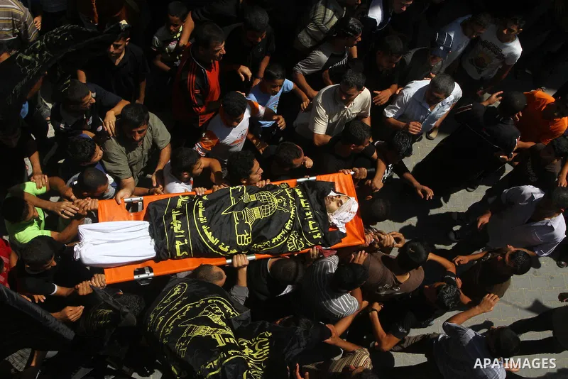 Palestinian mourners carry the body of Anwar Isleem, a commander in the Islamic Jihad militant during his funeral in Bureij Refugee Camp in central Gaza Strip on August 20, 2011 Anwar Isleem and Emad Abu Aabdeh were kill...