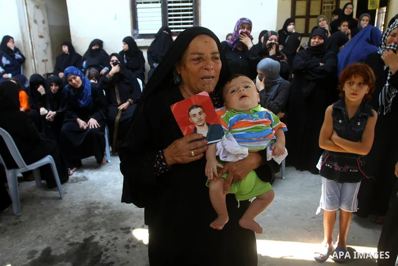 Relatives of Palestinian Islamic Jihad militant Anwar Isleem mourn during his funeral in Bureij Refugee Camp in central Gaza Strip on August 20, 2011. Anwar Isleem and Emad Abu Aabdeh were killed during an Israeli airstr...