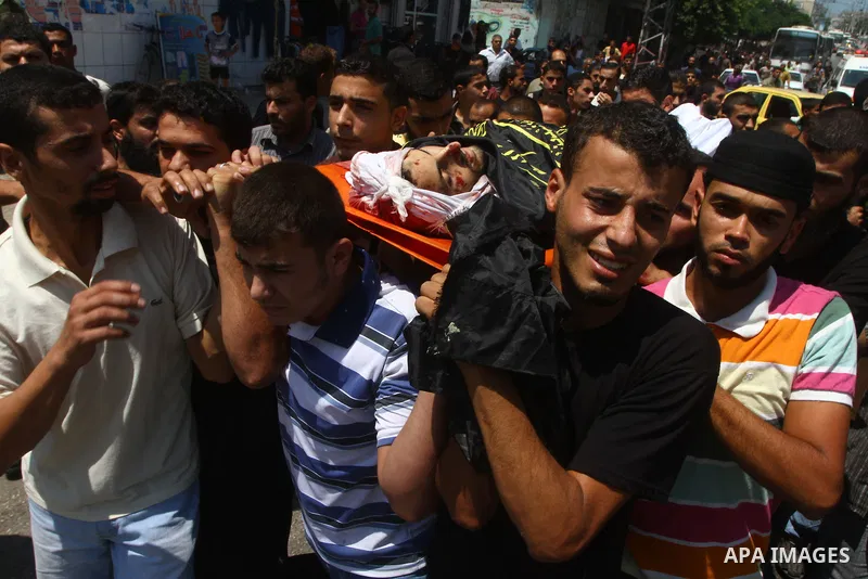 Palestinian mourners carry the body of Anwar Isleem, a commander in the Islamic Jihad militant during his funeral in Bureij Refugee Camp in central Gaza Strip on August 20, 2011 Anwar Isleem and Emad Abu Aabdeh were kill...