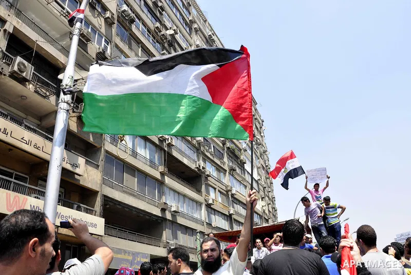 Demonstrators wave Egyptian (top) and Palestinian flags during a protest outside the Israeli embassy in Cairo on August 20, 2011. Egypt decided to recall its ambassador from Israel to protest the deaths of policemen kill...