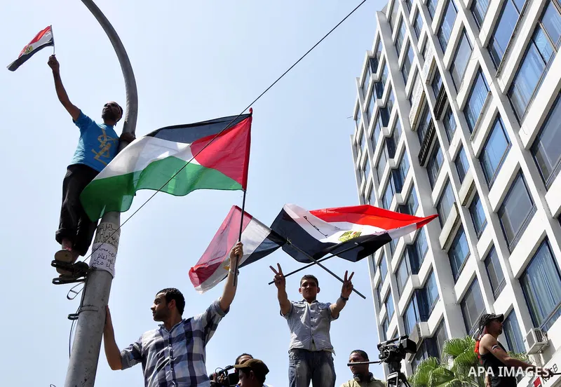 Demonstrators wave Egyptian (top) and Palestinian flags during a protest outside the Israeli embassy in Cairo on August 20, 2011. Egypt decided to recall its ambassador from Israel to protest the deaths of policemen kill...