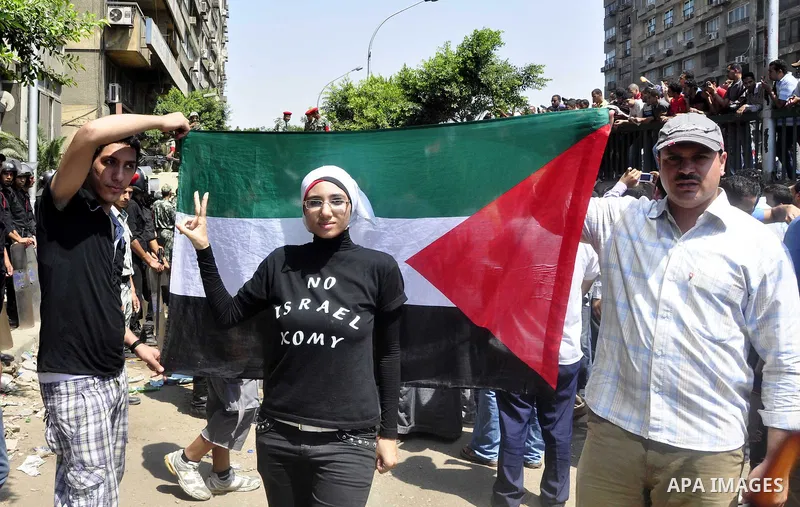 Demonstrators wave Egyptian (top) and Palestinian flags during a protest outside the Israeli embassy in Cairo on August 20, 2011. Egypt decided to recall its ambassador from Israel to protest the deaths of policemen kill...