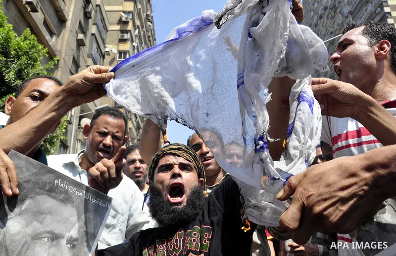 Egyptian demonstrators burn an Israeli flag during a protest outside the Israeli embassy in Cairo on August 20, 2011. Egypt decided to recall its ambassador from Israel to protest the deaths of policemen killed on the bo...
