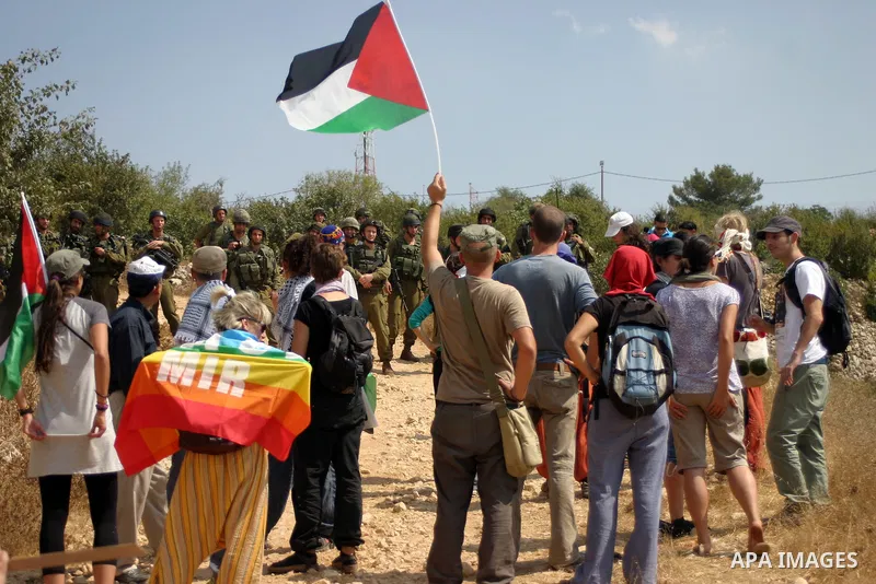 Israeli soldiers stand guard as Palestinians demonstrate along with left-wing Israelis and foreign peace activists in Beit Omar, near the West Bank city of Hebron on August 20, 2011 for the creation of a Palesitnian stat...