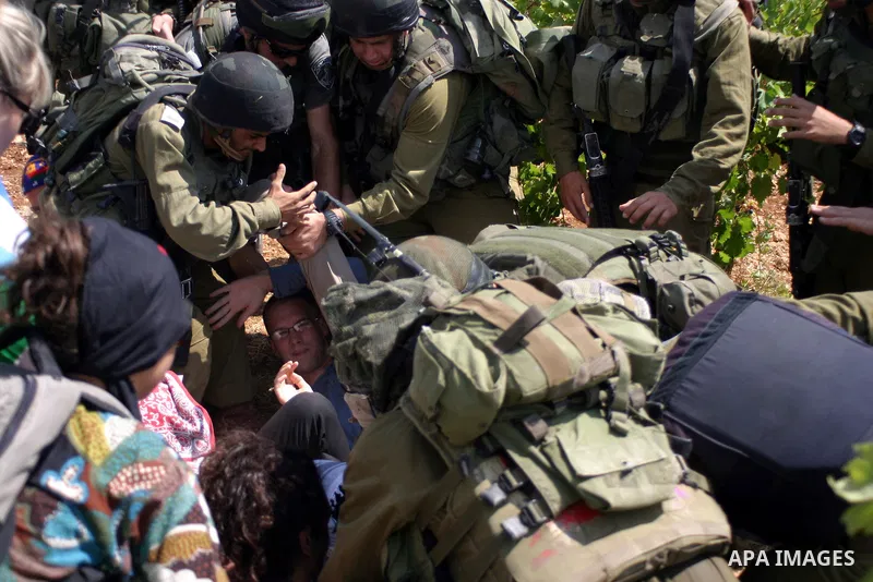 A demonstrator shouts anti-occupation slogans as Israeli soldiers try to detain him during a demonstration by locals, left-wing Israelis, foreigner peace activists in Beit Omar, near the West Bank city of Hebron on Augus...
