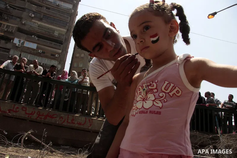 An Egyptian protester paints the Egyptian flag on a face of a little girl during a protest in front of the Israeli embassy in Cairo August 21, 2011. Egypt and Israel sought on Sunday to defuse a diplomatic crisis over th...