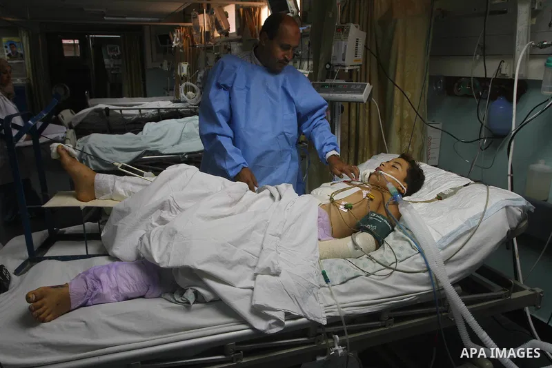 Ebrahim Al-Zaza, fifteen-years-old wounded Palestinian boy, receives a treatment inside the intensive care unit in al-Shefa hospital in Gaza City, Aug. 21, 2011. So far 15 Palestinians including three children were kille...
