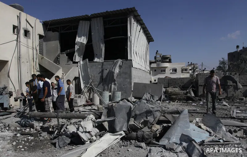 Palestinians inspect the damage at a Hamas training camp following an Israeli airstrike in Gaza City, Sunday, on Aug. 21, 2011. Militants in the Hamas-ruled Gaza Strip bombarded southern Israel with rockets and mortars S...