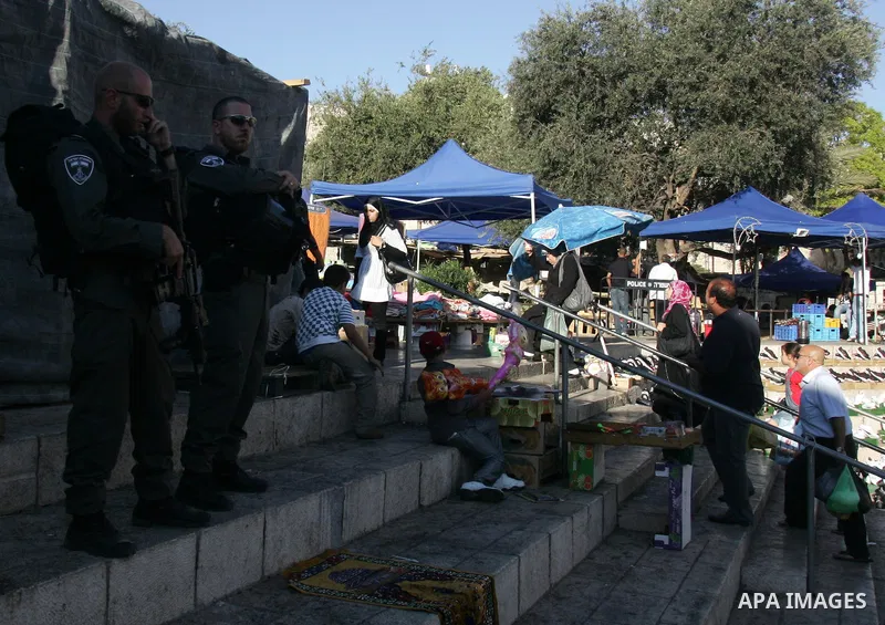 Palestinian Muslims walk past Israeli soldiers at a barricade near the Damascus Gate in East Jerusalem as Israel restricts attendance at the al-Aqsa Mosque in Jerusalem's Old City on August 21,2011.. Photo by Mahfouz Abu...