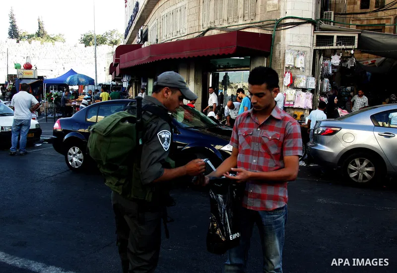 Palestinian Muslims walk past Israeli soldiers at a barricade near the Damascus Gate in East Jerusalem as Israel restricts attendance at the al-Aqsa Mosque in Jerusalem's Old City on August 21,2011.. Photo by Mahfouz Abu...
