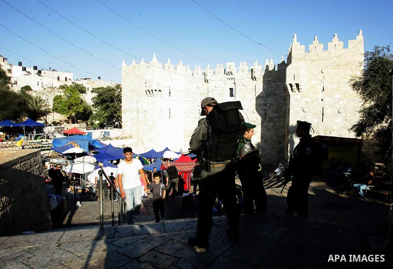 Palestinian Muslims walk past Israeli soldiers at a barricade near the Damascus Gate in East Jerusalem as Israel restricts attendance at the al-Aqsa Mosque in Jerusalem's Old City on August 21,2011.. Photo by Mahfouz Abu...