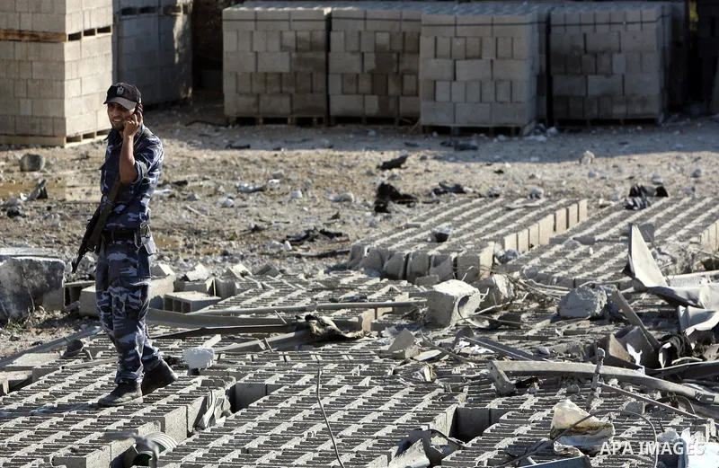 A Hamas security man inspects the damage at a Hamas training camp following an Israeli air-strike in Gaza City, Sunday, Aug. 21, 2011. Militants in the Hamas-ruled Gaza Strip bombarded southern Israel with rockets and mo...