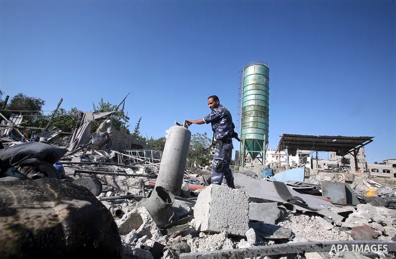A Hamas security man inspects the damage at a Hamas training camp following an Israeli air-strike in Gaza City, Sunday, Aug. 21, 2011. Militants in the Hamas-ruled Gaza Strip bombarded southern Israel with rockets and mo...