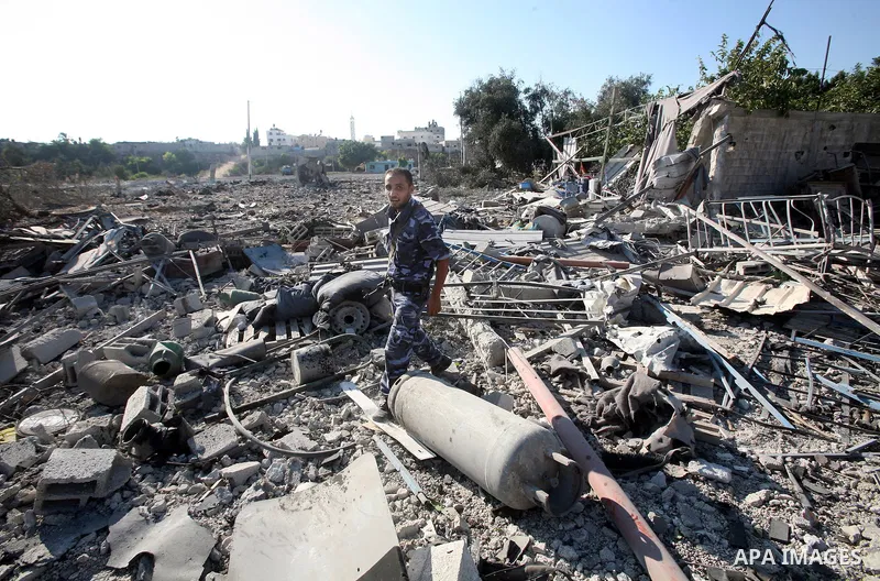 A Hamas security man inspects the damage at a Hamas training camp following an Israeli air-strike in Gaza City, Sunday, Aug. 21, 2011. Militants in the Hamas-ruled Gaza Strip bombarded southern Israel with rockets and mo...