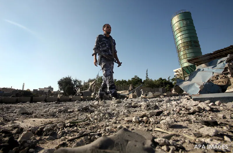 A Hamas security man inspects the damage at a Hamas training camp following an Israeli air-strike in Gaza City, Sunday, Aug. 21, 2011. Militants in the Hamas-ruled Gaza Strip bombarded southern Israel with rockets and mo...