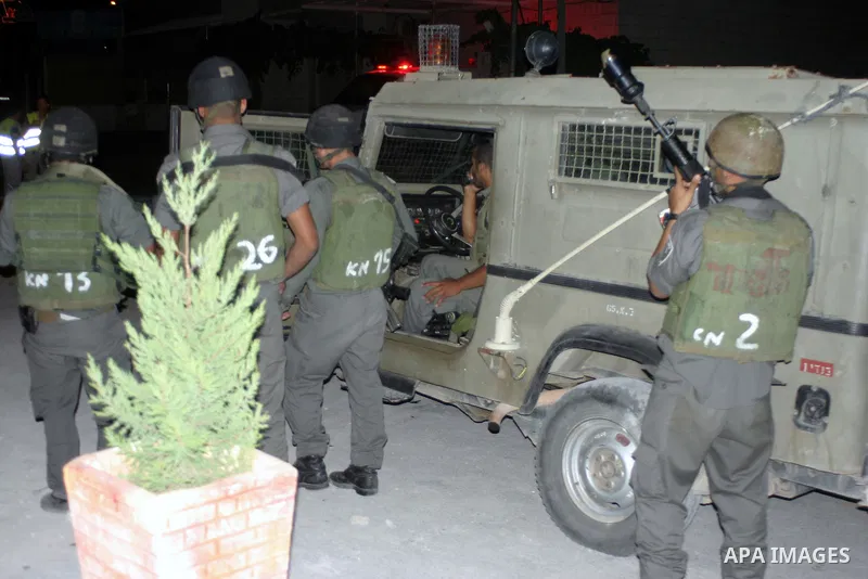 Israeli soldiers surround a neighbourhood during a military operation in the West Bank city of Hebron, early on 22 August 2011. Israel declared all-out war on Hamas, launching air strikes on its Gaza Strip stronghold and...