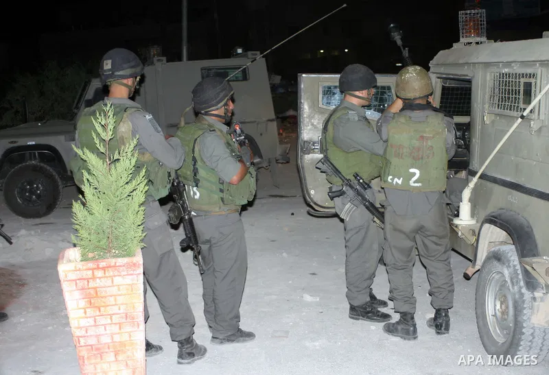 Israeli soldiers surround a neighbourhood during a military operation in the West Bank city of Hebron, early on 22 August 2011. Israel declared all-out war on Hamas, launching air strikes on its Gaza Strip stronghold and...