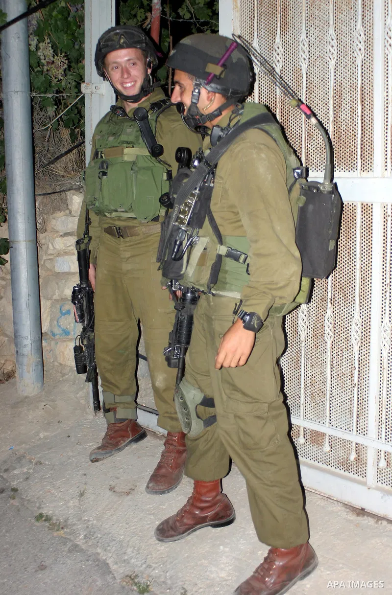 Israeli soldiers surround a neighbourhood during a military operation in the West Bank city of Hebron, early on 22 August 2011. Israel declared all-out war on Hamas, launching air strikes on its Gaza Strip stronghold and...