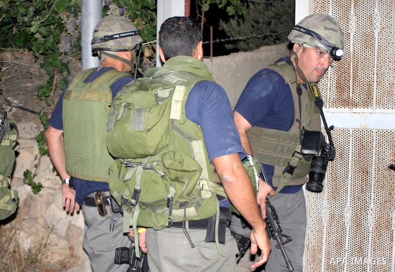Israeli soldiers surround a neighbourhood during a military operation in the West Bank city of Hebron, early on 22 August 2011. Israel declared all-out war on Hamas, launching air strikes on its Gaza Strip stronghold and...
