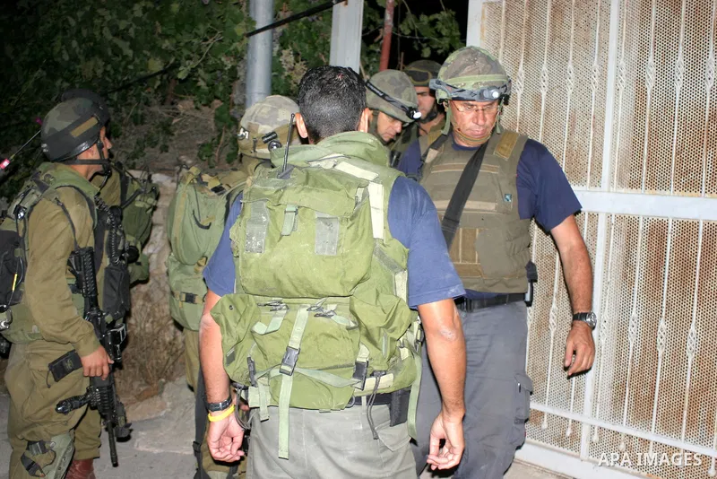 Israeli soldiers surround a neighbourhood during a military operation in the West Bank city of Hebron, early on 22 August 2011. Israel declared all-out war on Hamas, launching air strikes on its Gaza Strip stronghold and...