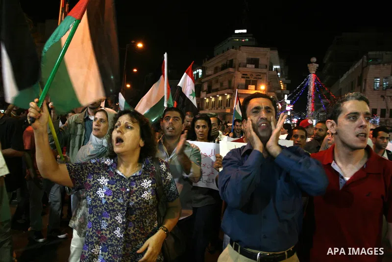 Palestinians take part in a protest against Israeli attacks over Gaza Strip in the West Bank city of Ramallah on Aug. 21, 2011. Photo by Issam Rimawi