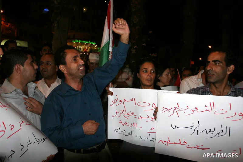 Palestinians take part in a protest against Israeli attacks over Gaza Strip in the West Bank city of Ramallah on Aug. 21, 2011. Photo by Issam Rimawi