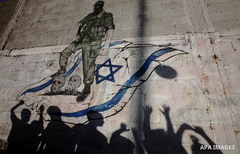 Palestinian children's shadows on a wall with a mural depicting a Palestinian fight and an Israeli flag in the Jabaliya Refugee Camp in northern Gaza Strip on 22 August 2011 Reports state that Palestinian militants fired...