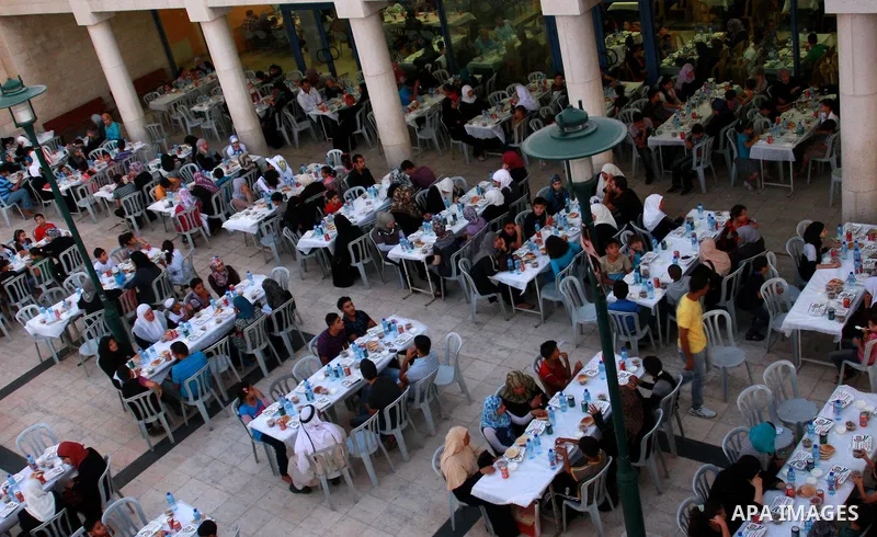 Palestinians take part in the Central Ramadan breakfast for the first orphanage, organized by the United Arab Emirates State charity , in the West Bank city of Nablus, monday Aug . 22,2011. Muslims throughout the world a...