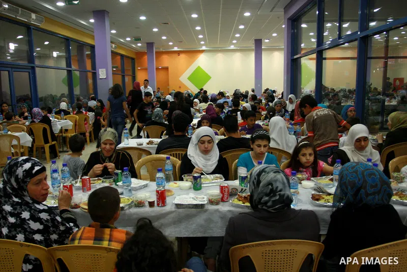 Palestinians take part in the Central Ramadan breakfast for the first orphanage, organized by the United Arab Emirates State charity , in the West Bank city of Nablus, monday Aug . 22,2011. Muslims throughout the world a...
