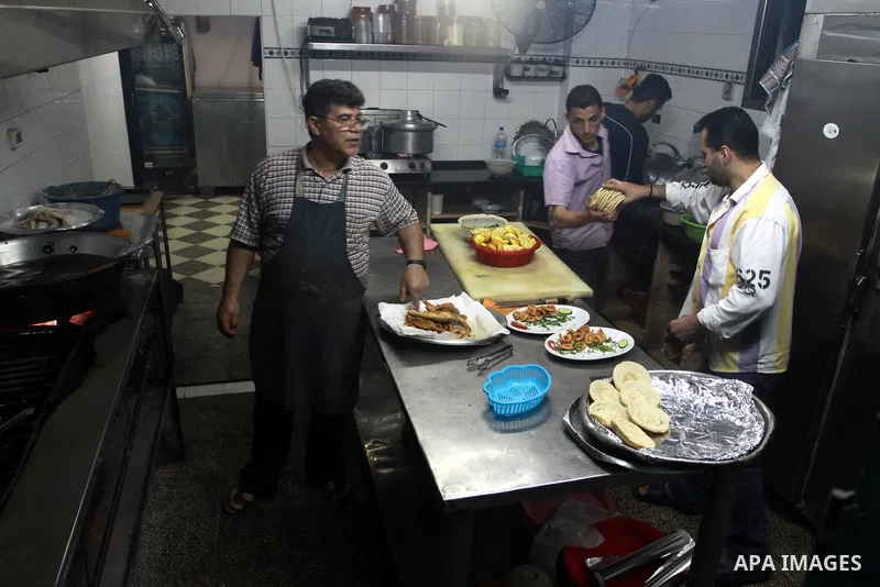 In this photo taken on May 5, 2011: A Palestinian Chef and his assistant prepare seafood at the Moneer abu Hassira restaurant in Gaza city, ordinary people and politicians alike are served top-class seafood at the Moneer...