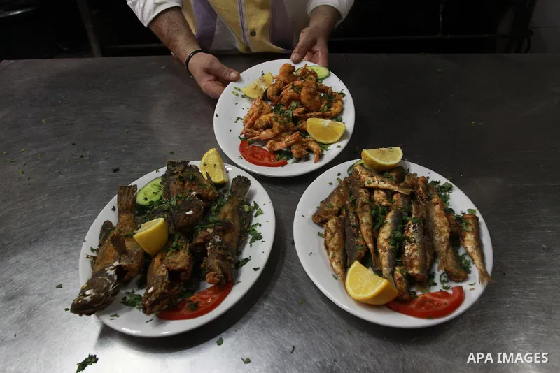 In this photo taken on May 5, 2011: A Palestinian assistant Chef prepares seafood at the Moneer abu Hassira restaurant in Gaza city, ordinary people and politicians alike are served top-class seafood at the Moneer abu Ha...
