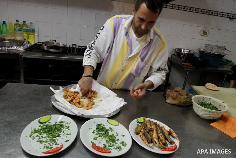 In this photo taken on May 5, 2011: A Palestinian assistant Chef prepares seafood at the Moneer abu Hassira restaurant in Gaza city, ordinary people and politicians alike are served top-class seafood at the Moneer abu Ha...