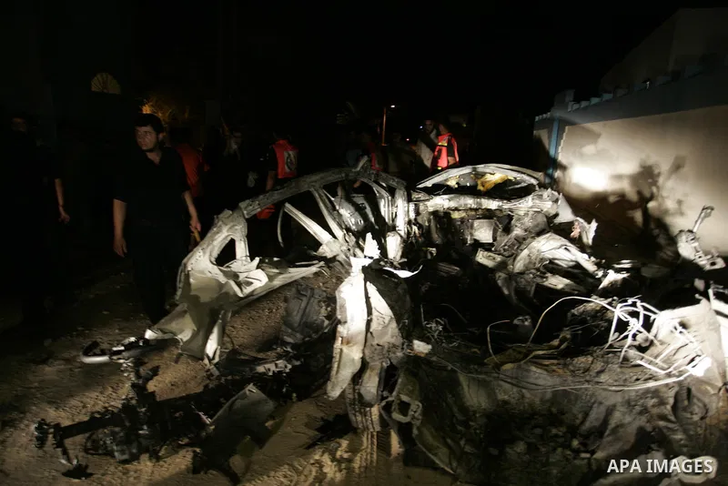 Palestinians look at the wreckage of a car after it was hit by an Israeli missile, killing an Islamic Jihad militant in Rafah, southern Gaza Strip, early Wednesday, Aug. 24, 2011. The Israeli military said the gunman had...