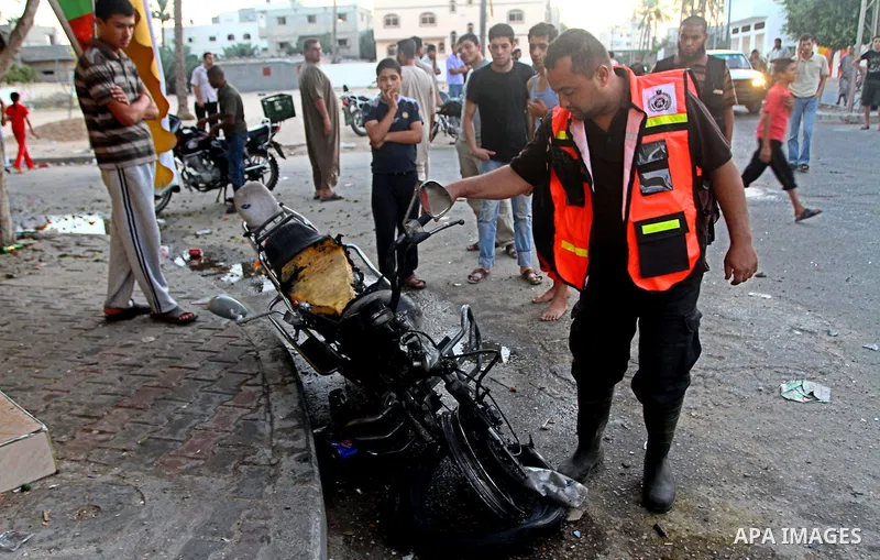 Palestinians inspect a motorcycle damaged in an Israeli air strike in Deir al-Balah in the central Gaza Strip on August 24, 2011. An Israeli strike killed Ismael al-Ismar, 34, in Rafah scarcely 48 hours after militant fa...