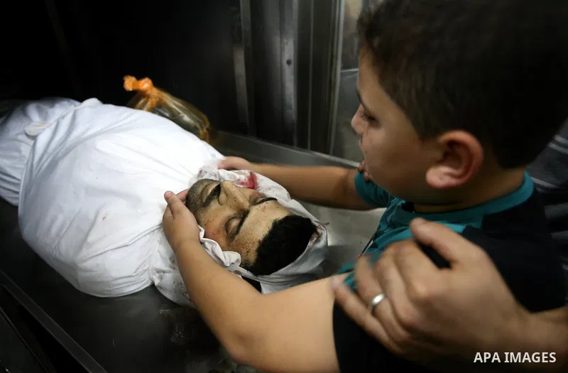 The son of Palestinian Islamic Jihad militant Ismael Al-Asmar mourn over his body at Rafah hospital after an Israeli air strike hit his car in Rafah in the southern Gaza Strip on 24 August 2011. Al-Asmar, one of the mili...